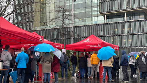 Protestaktion vor Thyssenkrupp Gebäube, rote Zelte mit versammelten Personen  