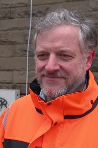 Mann mit oranger Jacke