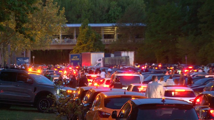 Zahlreiche Autos stehen dicht hintereinander auf einem großen Platz.
