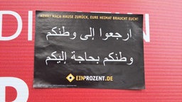 Hetz-Aufkleber auf Wahlplakat