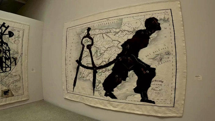 Bild eines Kunstwerks an der Wand, das unter anderem die Silhouette eines Mannes zeigt