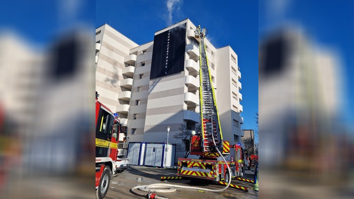 Eine brennende Wohnung in einem Hochhaus wird gelöscht 
