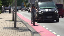 Eine Fahrradfahrerin fährt auf einem Fahrradstreifen auf der Straße