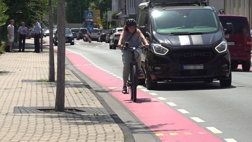 Eine Fahrradfahrerin fährt auf einem Fahrradstreifen auf der Straße