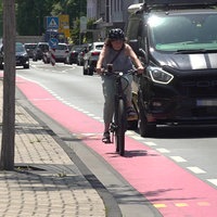 Eine Fahrradfahrerin fährt auf einem Fahrradstreifen auf der Straße