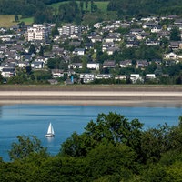 Ein See liegt mitten in der Natur und ist umgeben von mehreren Wohnhäusern