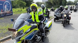 Polizist auf Motorrad gefolgt von anderen Motorradfahrern