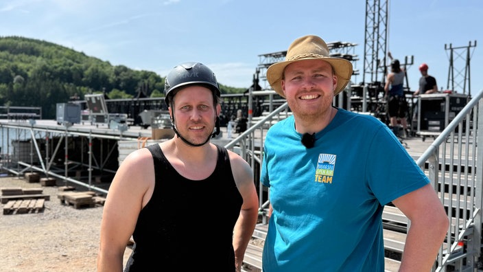 Zwei Männer stehen vor unfertiger Bühne und schauen in die Kamera, Bühnenbauer Dirk Joachimsmeier und Veranstalter Lars Harsveldt