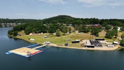 Luftaufnahme des Biggesee Open Air Festivalgeländes, Bühne im Bau, große Liegewiese, Wasser