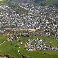 Stadtansicht von Olpe von oben mit vielen Häusern und einer grünen Landschaft 