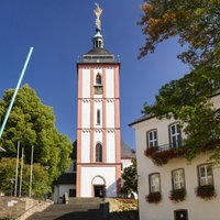 Eine Kirche mit einem sechseckigen Grundriss, steht im Mittelpunkt eines Rathausplatzes.