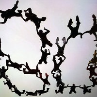 28 Personen bilden beim Fallschirmspringen gemeinsam die Zahl 80 am Himmel.