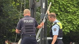 Zwei Männer in Polizei-Uniform nehmen Messungen vor