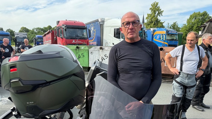 Ein Mann steht neben einem Motorrad