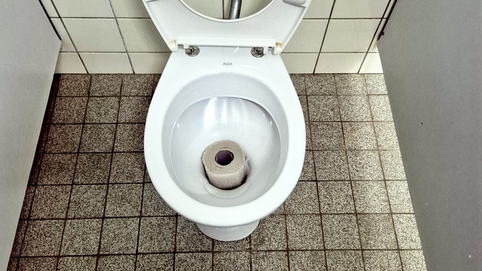 In einer Toilette steckt eine Toilettenrolle
