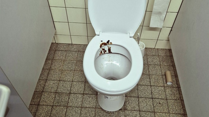 Eine Toilette ist mit Kot beschmiert