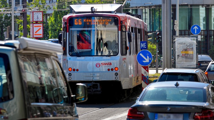 Eine Strassenbahn inmitten von Autoverkehr in Bonn