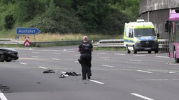 Ein Polizist untersucht die Unfallstelle auf der A3