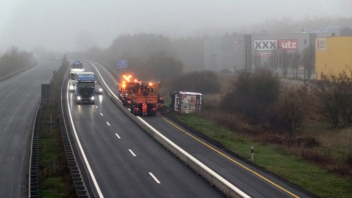 Lkws und ein Pkw fahren an einem Räumfahrzeug auf der A30 vorbei