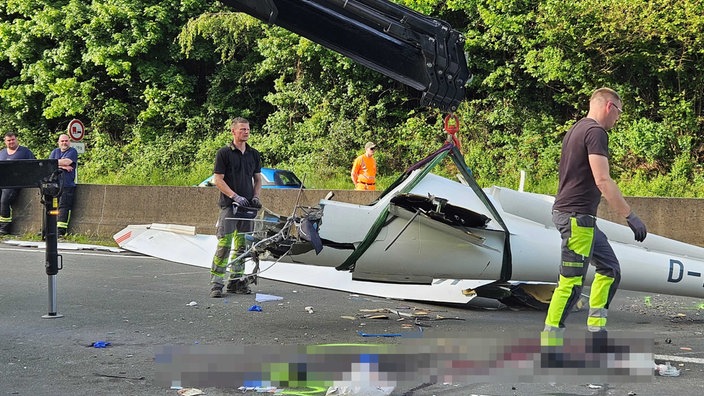 Rettungskräfte arbeiten daran, das Flugzeug von der Autobahn zu bergen