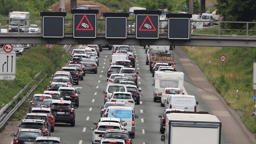 Autos, Lastwagen und Wohnmobile stehen auf der Autobahn im Stau.