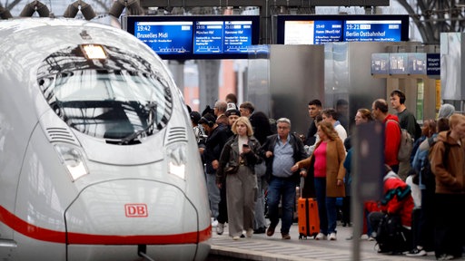 Mehrere Personen auf einem Gleis des Kölner Hauptbahnhofs, kurz bevor sie in einem ICE einsteigen