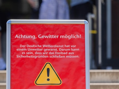Auf einem Schild wird vor möglichen Gewittern gewarnt