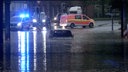 Ein Auto steht in einer überfluteten Straße in Rheine