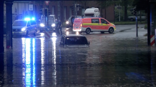 Ein Auto steht in einer überfluteten Straße in Rheine