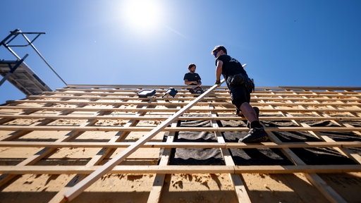 Dachdecker arbeiten unter der sengenden Sonne bei über 30 Grad auf dem Dach eines Hauses im Rhein-Sieg-Kreis