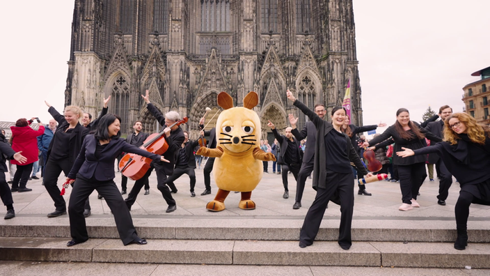 Die Maus tanzt gemeinsam mit Rettungssanitäterinnen und Rettungssanitätern