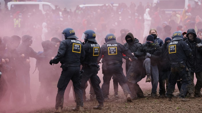 Police in riot gear scuffle with protesters during confrontations near the settlement of Luetzerath on January 14, 2023 near Erkelenz, Germany.