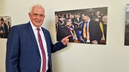 Günther Bergmann (CDU) zeigt ein Ausstellungsfoto mit Armin Laschet und dem damaligen niederländischen Ministerprädidenten Mark Rutte 