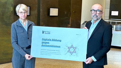 NRW-Schulministerin Dorothee Feller (CDU) und Bert Römgens, Verwaltungsdirektor der Jüdischen Gemeinde, im Landtag NRW