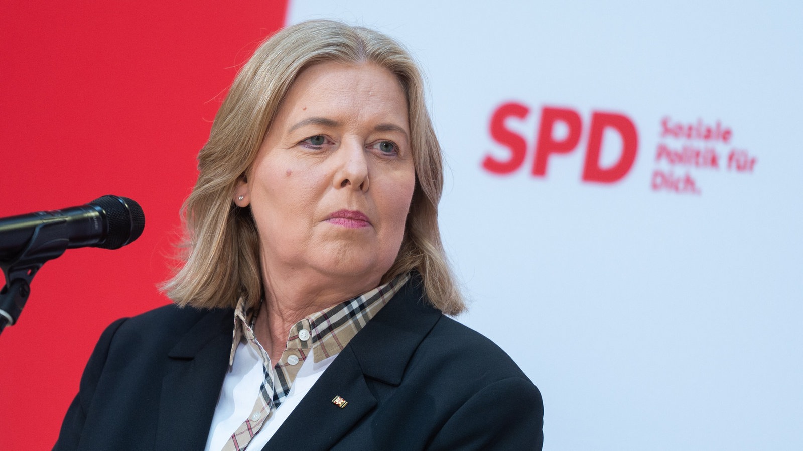 Bärbel Bas steht vor einem Mikrofon, im Hintergrund ist unscharf das SPD-Logo zu sehen