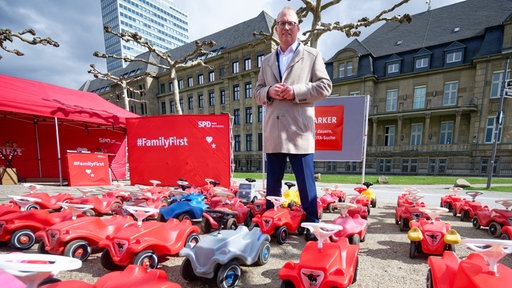 Jochen Ott, Vorsitzender der SPD Fraktion im Landtag von NRW, steht beim Auftakt der Dialogtour "Fraktion auf Achse" zwischen Bobby-Cars vor der Staatskanzlei