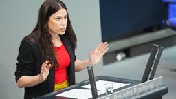 15.05.2025, Berlin: Cansin Köktürk (Die Linke) steht an einem Pult und spricht im Plenarsaal im Bundestag zu den Abgeordneten. 