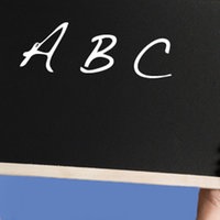Eine Frau hält eine Tafel mit der Aufschrift "ABC" hoch