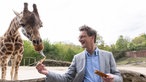 NRW-Ministerpräsident Hendrik Wüst (CDU) füttert eine Giraffe