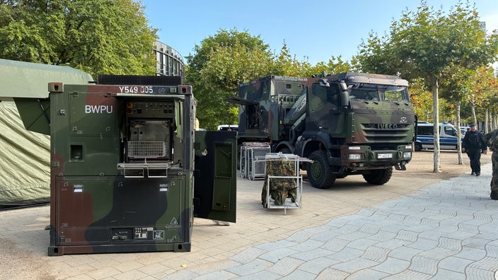 Bundeswehr-LKW und andere Ausrüstung in Tarnfarben stehen auf dem Platz vor dem NRW-Landtag