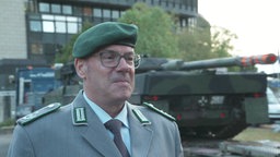 Ulrich Fonrobert, Pressestab Bundeswehr  im Interview. Im Hintergrund steht ein Panzer vor dem NRW-Landtag