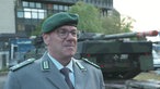 Ulrich Fonrobert, Pressestab Bundeswehr  im Interview. Im Hintergrund steht ein Panzer vor dem NRW-Landtag