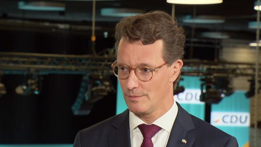 Ministerpräsident Hendrik Wüst guckt Richtung Interviewer im Sommerinterview von Westpol