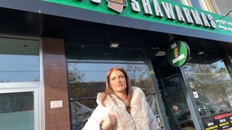 Die Influencerin Babu steht vor dem Schawarma-Imbiss