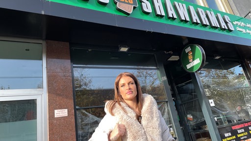Die Influencerin Babu steht vor dem Schawarma-Imbiss