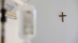  Ein Krankenzimmer im Katholischen Krankenhaus KKH in Erfurt. Ein Kreuz hängt an der weißen Wand und im Vordergrund verschwommen Krankenhaus Einrichtung.