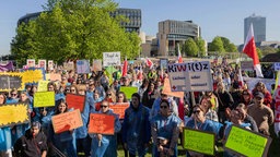 Demonstrierende sind vor dem NRW-Landtagsgebäude versammelnt und halten Schilder hoch.