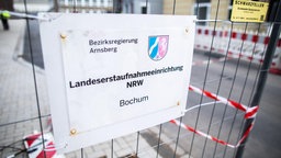 Zu sehen ist ein Schild mit der Aufschrift "Landeserstaufnahmeeinrichtung NRW"