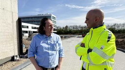 Zu sehen ist Elektromeister Martin Böhm aus Troisdorf (links) mit seinem Kunden Deniz Keskin (rechts)