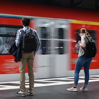 zwei junge Menschen stehen am Bahnsteig
